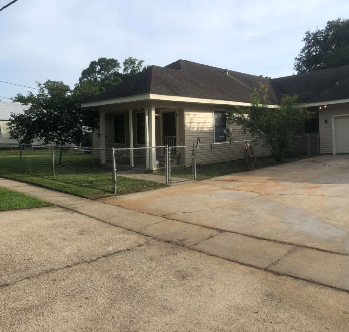 After: the same house with a clean-cut lawn, trimmed fence line and weed-free driveway
